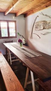 ein Holztisch mit einer Vase mit Blumen darauf in der Unterkunft Shelter Patagonia Hostal in El Bolsón