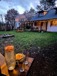 ein Tisch mit zwei Gläsern mit Orangen in einem Hof in der Unterkunft Shelter Patagonia Hostal in El Bolsón