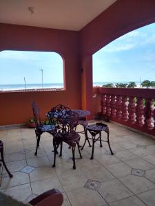 a room with tables and chairs and a balcony at Pé na areia in Ilha Comprida