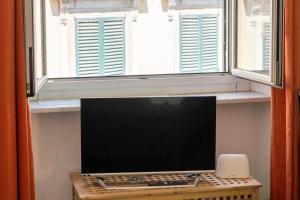 een computer op een tafel voor een raam bij La Genova storica dal monolocale in Genua