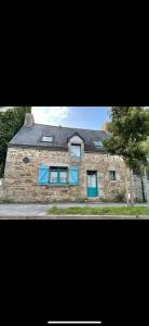 a large stone house with blue shutters on it at Charmant penty avec cheminée in Sainte-Hélène