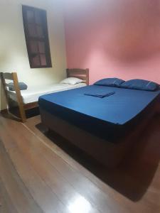 a large blue bed in a room with a bench at NóIS DE CASA HOSTEL & SUÍTES in Belo Horizonte +40 photos
