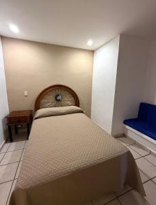 a bedroom with a large bed and a blue bench at Departamento Cielo in Puerto Vallarta +24 photos