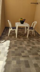 un tavolo con due sedie e un tavolo con una pianta di Residencial Franco Casa 01 a Primavera do Leste