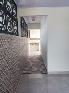 un corridoio con pavimento piastrellato e parete bianca di Residencial Franco Casa 01 a Primavera do Leste