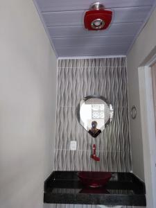 un bagno con un lavandino rosso e uno specchio di Residencial Franco Casa 01 a Primavera do Leste