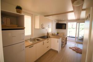 a kitchen with white cabinets and a sink at Luxury Houseboat Lavender in Portorož