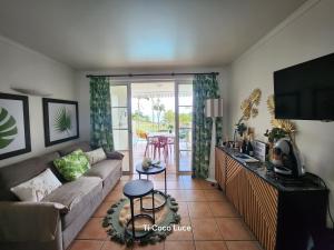 ein Wohnzimmer mit Sofa und Fernseher in der Unterkunft Ti coco luce studio à Sainte Luce dans village de vacances in Sainte-Luce