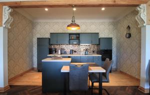 a kitchen with blue cabinets and a table with chairs at Ferienwohnung 2 im Gutshaus Mühlhof in Prenzlau