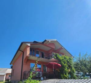 a pink building with a balcony and an umbrella at Dino's Apartments in Plav +4 photos
