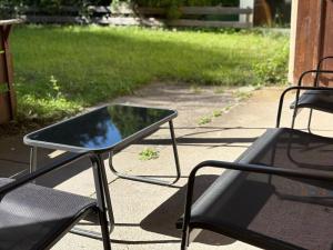 a glass table and two chairs on a patio at Garden Retreat - Küche - Bad - Garten in Niedernhall