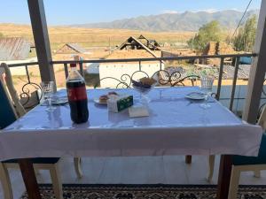 a table with a bottle of cocacola on a balcony at GUEST HOUSE EcoNest & HORSE RIDING TOURS TO SONG-KOL LAKE in Kyzart