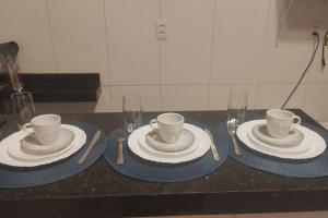 a table with plates and cups and wine glasses at Loft Marajó in Soure +6 photos