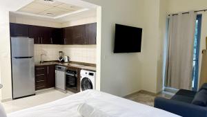 a kitchen with a refrigerator and a stove at JBR Studio Apartment - Bay Central in Dubai