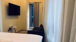 a room with a bed and a chair and a window at JBR Studio Apartment - Bay Central in Dubai