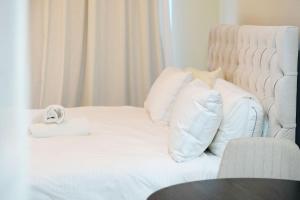 a white bed with a stuffed animal sitting on it at JBR Studio Apartment - Bay Central in Dubai
