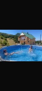 two people swimming in a large swimming pool at Jezerina in Šavnik
