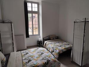 a bedroom with two beds and a window at O'Couvent - Appartement 131 - 2 chambres - 90 m2 - Troisième étage in Salins-les-Bains