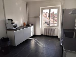 a small kitchen with a microwave and a window at O'Couvent - Appartement 131 - 2 chambres - 90 m2 - Troisième étage in Salins-les-Bains