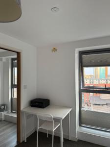 a white table and chair in a room with a window at Birmingham City Centre-2 Mins to Station, City Views in Birmingham +3 photos