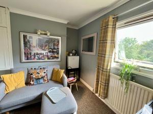 Una sala de estar con un sofá y una ventana. en Garden View Cedar House Room 7, en Hereford