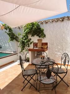 a table and chairs sitting under a white umbrella at La Antigua Estación - Río Mundo Agramón in Agramón