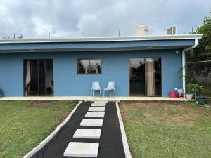 a blue house with two chairs in front of it at Coconut House in Alajuela City