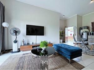 a living room with a blue couch and a table at 13 Sunningdale - Jackals Creek Golf Estate in Roodepoort