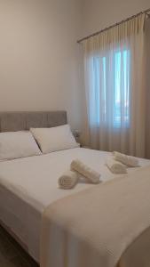 a white bed with towels on it with a window at Luxury Maisonette in Ioannina