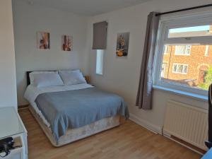 a bed in a room with a window and a bed sidx sidx sidx at private room with shared bathroom 20 minutes walk to Durham centre in Gilesgate