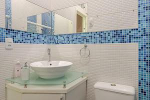 ein Badezimmer mit Waschbecken, Toilette und Spiegel in der Unterkunft Apartamento Grande e Climatizado em Florianópolis in Florianópolis + 18 Fotos