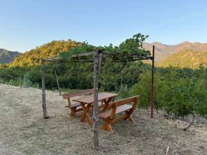 a wooden picnic table sitting on top of a hill at ORAHOVSTICA TRAIL - Glamping in Dupilo