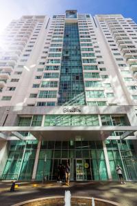 a tall building with people standing outside of it at Flat Alto Padrão no Saint Moritz - Localização Central e Wi-Fi Rápido in Brasilia