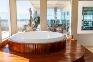a large bath tub in a room with a table at Flat Alto Padrão no Saint Moritz - Localização Central e Wi-Fi Rápido in Brasilia