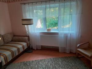 ein Wohnzimmer mit Sofa und Fenster in der Unterkunft Dubavi in Viestura Laukums