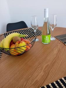 a bowl of fruit on a wooden table with wine glasses at MAGIA's HOUSE in Karistos +8 photos