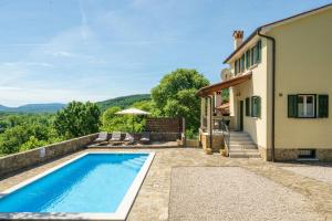 a house with a swimming pool next to a building at Villa Daus in Cerovlje