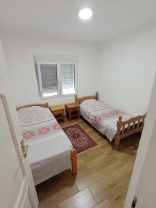 two beds in a room with two windows at Smeštaj Golubica in Soko Banja