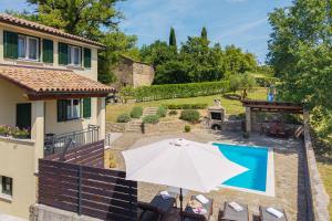a patio with an umbrella and a swimming pool at Villa Daus in Cerovlje