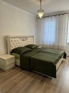 a bedroom with a large bed and a chandelier at Clara in Alaverdi