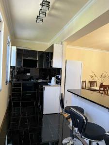 a kitchen with black and white appliances and chairs at Clara in Alaverdi