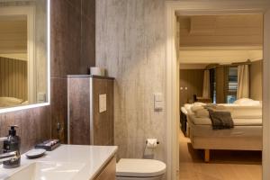 a bathroom with a sink and a toilet and a bed at Villa Oleanna in Lysekloster +129 photos