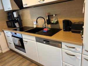 a kitchen with a sink and a stove top oven at Privatzimmer im Reihenhaus nähe Flughafen Hannover Langenhagen in Hannover +4 photos