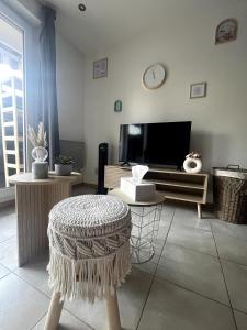 a living room with a tv and a stool at Studio pratique - Jardin privé in Grabels