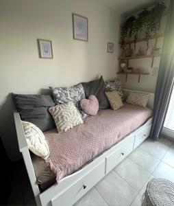 a couch with pillows on it in a room at Studio pratique - Jardin privé in Grabels