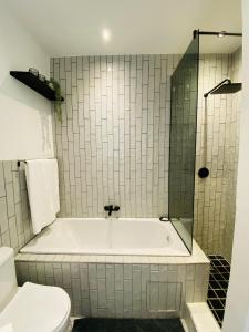 Ένα μπάνιο στο The Monochrome Apartment 209 - Urban Chic Escape - Open Plan Bathroom with Bathtub