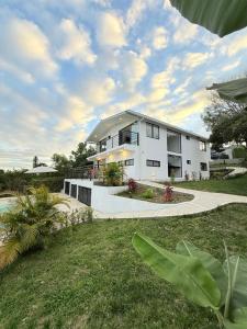 a large white house with a grass yard at Villa Verde in Silvania