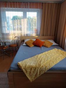 a bedroom with a bed with yellow and orange pillows at Agroturystyka u Marty in Tylicz