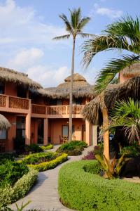 a resort with palm trees and a walkway at La Posada Hotel Boutique in Manzanillo