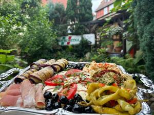 a tray of food with meat and vegetables on it at Pizzeria & Pension ETNA in Waren